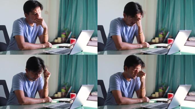 亚洲男子工作笔记本电脑，担心的男子压力工作场所，沮丧的男子看着笔记本电脑屏幕
