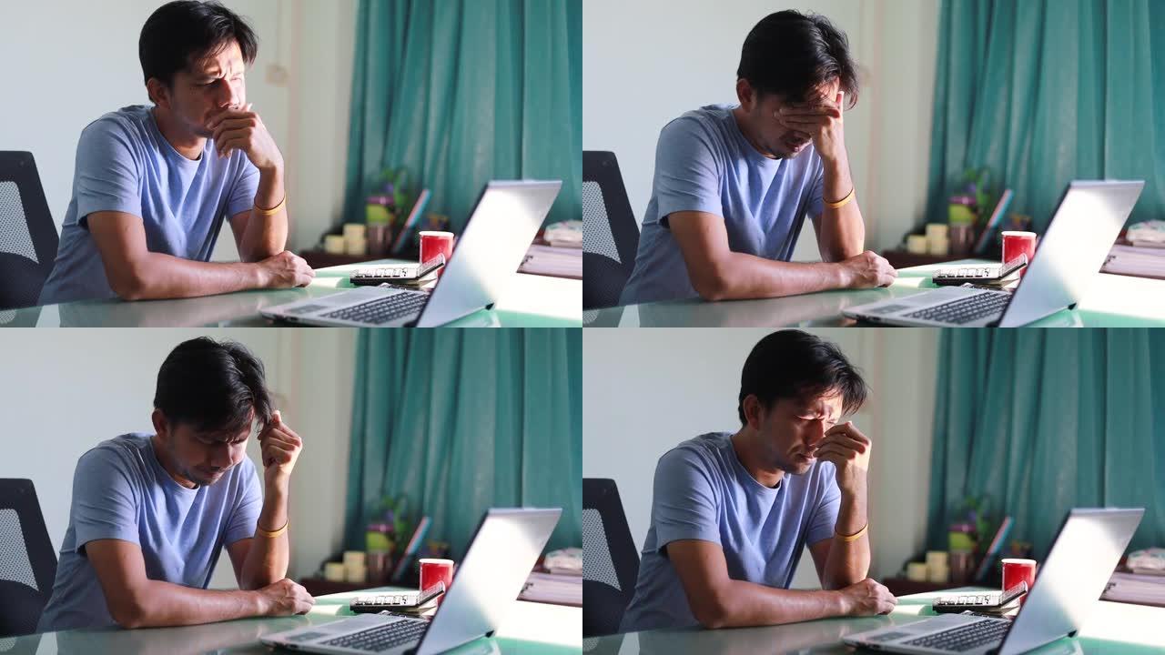 亚洲男子工作笔记本电脑，担心的男子压力工作场所，沮丧的男子看着笔记本电脑屏幕