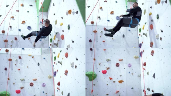 年轻人从室内人工攀岩岩壁下降