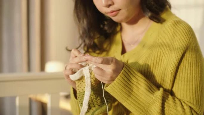 用白色羊毛编织的年轻亚洲女性。