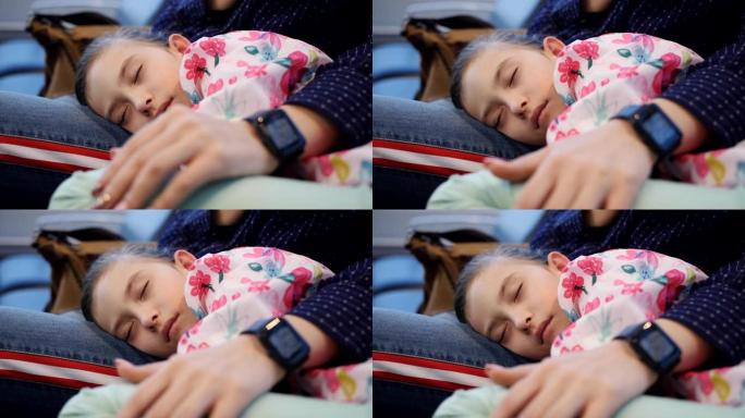 母女睡在机场的椅子上等待延误的航班，特写镜头，熟睡的小女孩