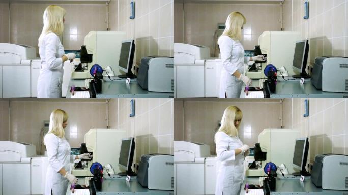 女性实验室助理在现代设备上分析血液样本。高清