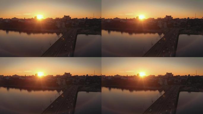 俄罗斯沃罗涅日市切尔尼亚夫斯基大桥上的日落鸟瞰图，车流。无人机镜头，城市交通