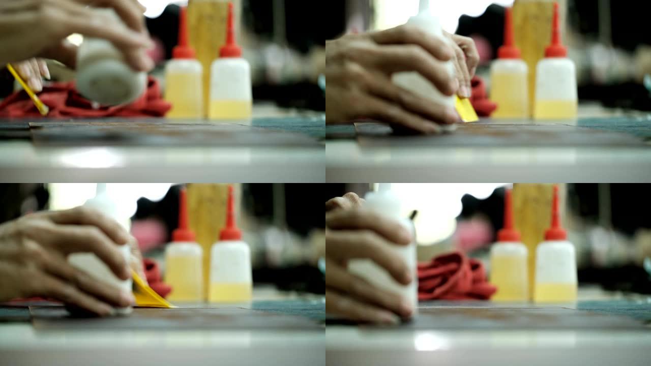 皮革工厂背景中涂胶和修剪裁缝的特写
