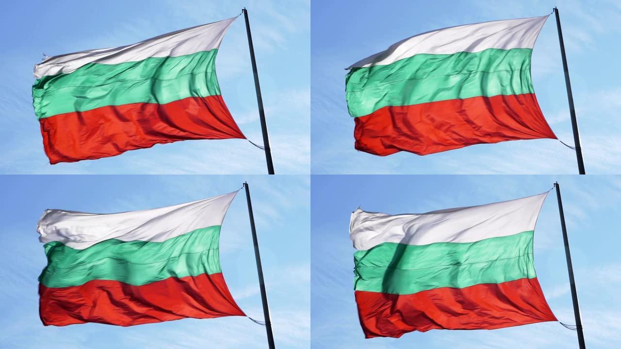 保加利亚人在蓝天下挥舞着旗杆上的丝绸旗帜