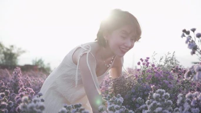 年轻女子手穿花圃田野，触摸野花特写