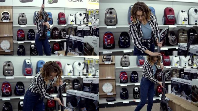 开朗的卷发女人站在家电商店的新吸尘器附近，选择合适的吸尘器。各种真空吸尘器排成一排。慢动作