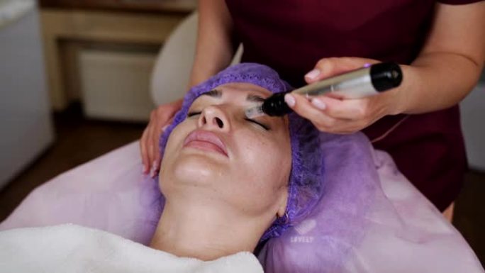 美容师在患者脸上进行水力剥离和清洁程序。面部皮肤保湿、去角质和年轻化。