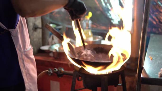 男子炒米粉。泰国中国城热锅里的泰国街头快餐。