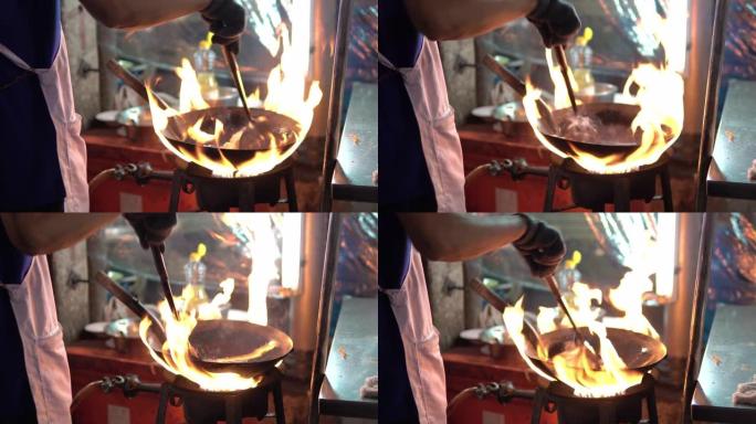 男子炒米粉。泰国中国城热锅里的泰国街头快餐。