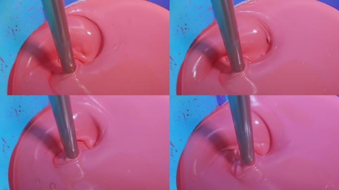在桶中混合油漆，在工厂中混合油漆，工厂自动混色。在工厂中混合粉红色涂料