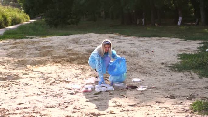 一个穿着衬衫的年轻女孩在湖边公园的海滩上收集垃圾。