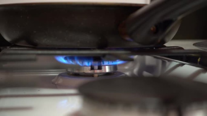 煎锅着火了。煤气炉的火使锅变暖。
