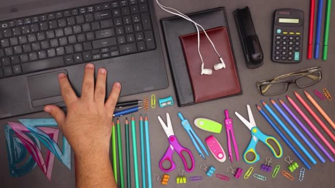 男子用手指在带商务用品的桌子上的现代笔记本电脑上的触摸板上滚动 -- 停止运动