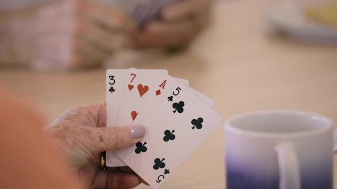 扑克牌-一个女人将扑克手放到框架中