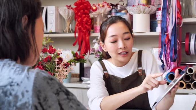 花店主亚洲女人接到订单准备店内销售，一个日本女人与专业花店，小企业概念。