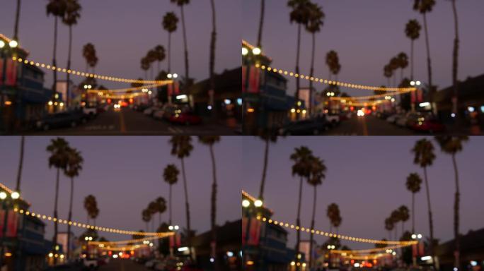 装饰性的凝视花环灯，棕榈树轮廓，傍晚的天空。背景模糊。加州用灯装饰的街道。节日照明、海滩派对、热带度