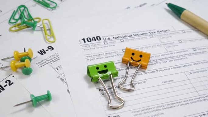 W-9和1040 Taxe表格，桌子上有微笑活页夹