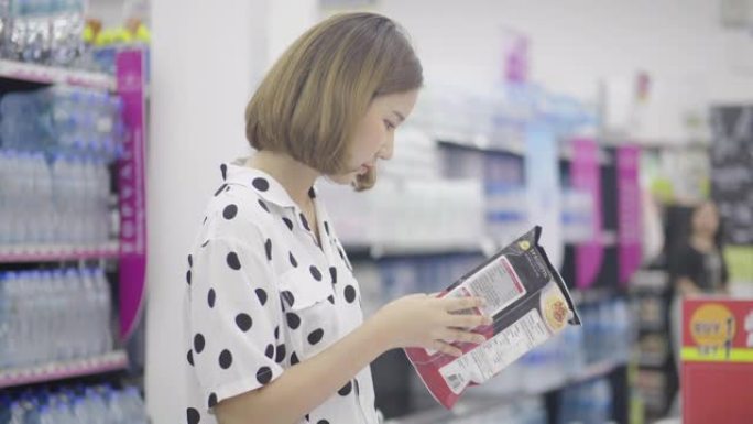 年轻的亚洲妇女在超市购物