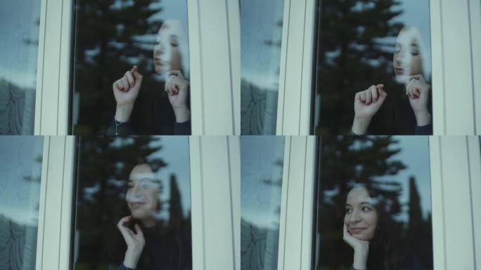 年轻女子吹窗户，用手指画画