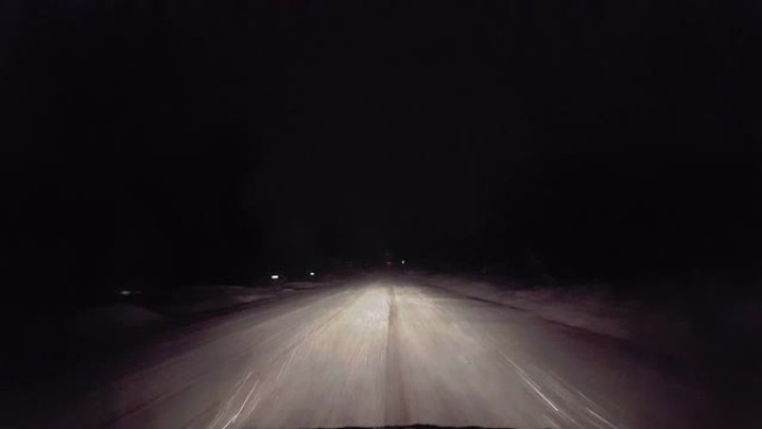 晚上在乡村公路上下雪时开车。司机的观点是冬天晚上的雪和雪花