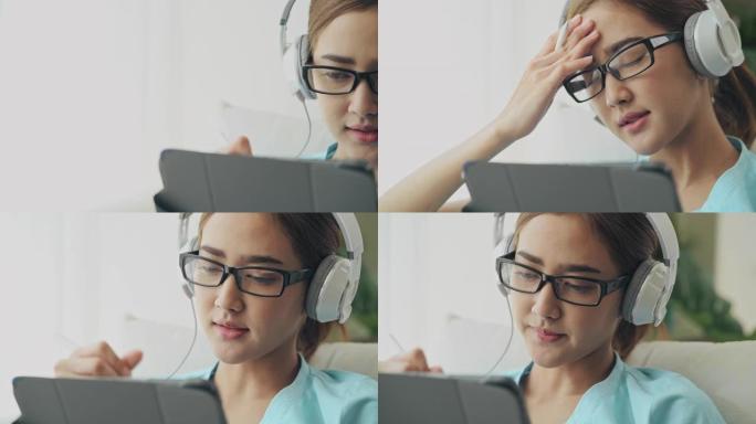 特写多莉拍摄的亚洲女性在数字平板电脑上写作，思考。