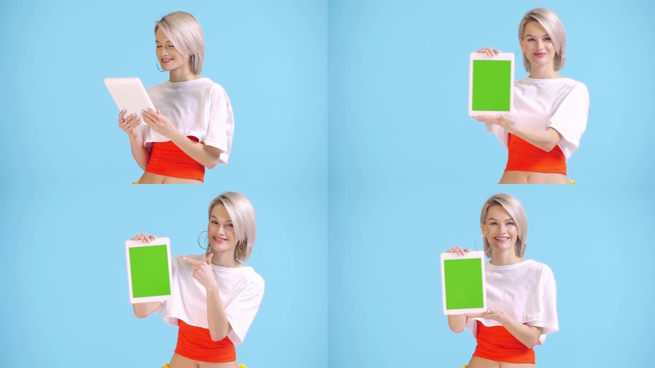 微笑的女孩显示数字平板电脑，绿色屏幕孤立在蓝色