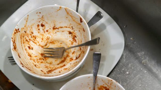 成年男性白人在意大利面肉丸和红酱晚餐后放下脏盘子