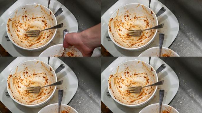 成年男性白人在意大利面肉丸和红酱晚餐后放下脏盘子