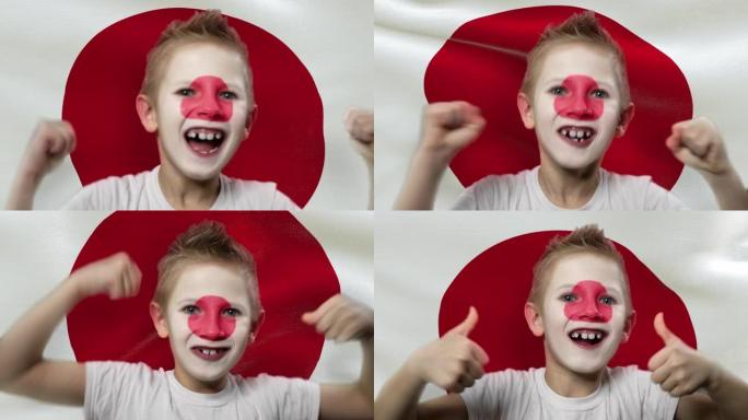 日本国旗背景上的快乐粉丝。有着民族色彩的脸的快乐男孩。