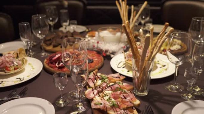 餐厅装饰精美的餐饮宴会桌特写，配有小吃和沙拉。改变焦距的相机拍摄