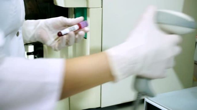 女科学家在实验室的现代设备上分析血液样本。高清