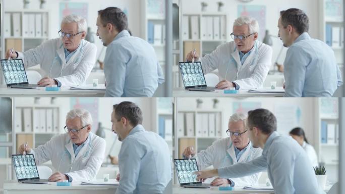 高级医生向男性患者显示笔记本电脑上的x射线