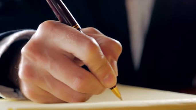 商人用笔在法律笔记本上手写的特写镜头