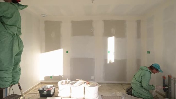 两名画家在新房子里画墙壁和天花板