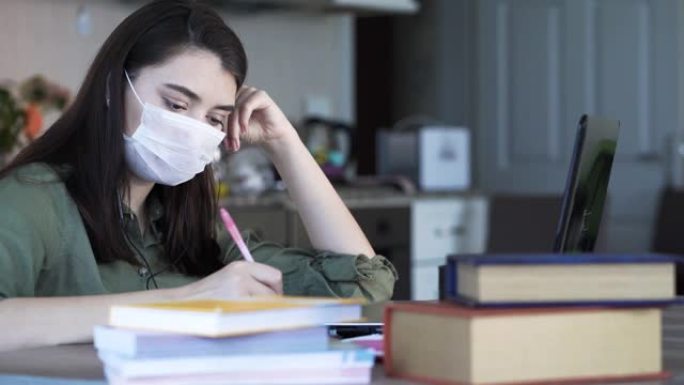 女人在家学习，脸上戴着医用口罩