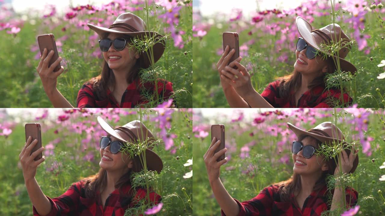 宇宙草地上亚洲成熟女性的面部表情，另类生活方式放松，退休，使用智能手机拍照带花