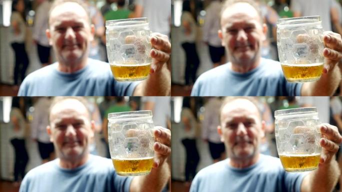一名中年男子在酒吧里拿着杯子里的冰啤酒