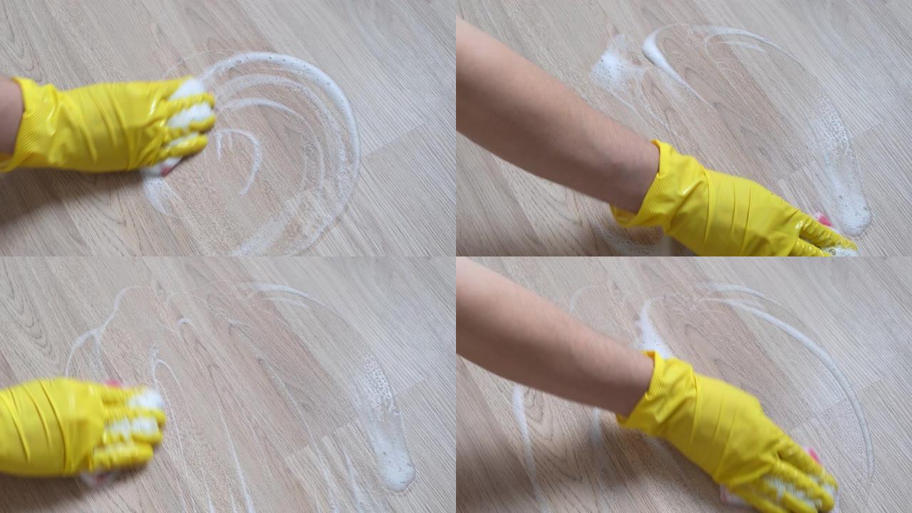一只戴着黄色手套的女性手擦拭木质表面。特写。