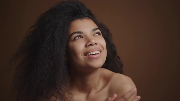 裸体快乐的非洲裔美国妇女触摸她完美的皮肤脸和肩膀