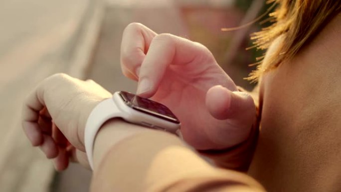 女人使用她的智能手表触摸屏可穿戴技术设备。