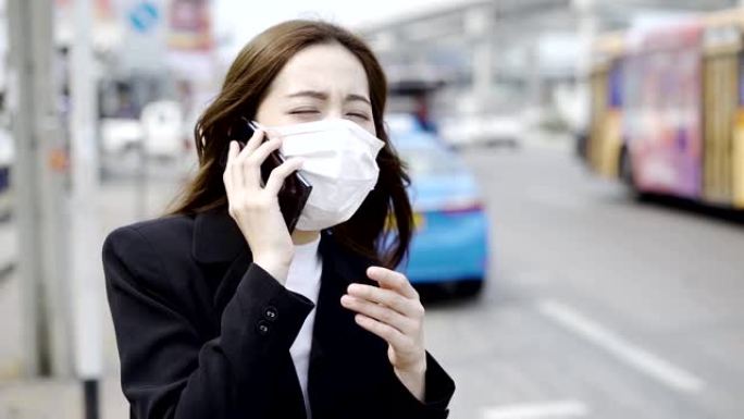 亚洲妇女的嘴咳嗽到她的手，以防止新型冠状病毒肺炎传播