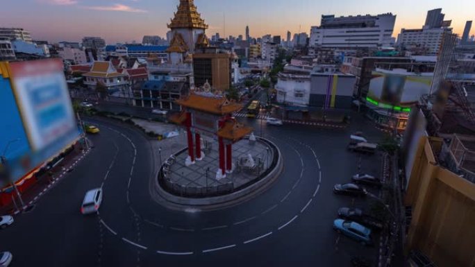 在美丽的日出时间流逝，有车辆、汽车和公共汽车，用于在泰国曼谷中国城中国门地标周围的交通