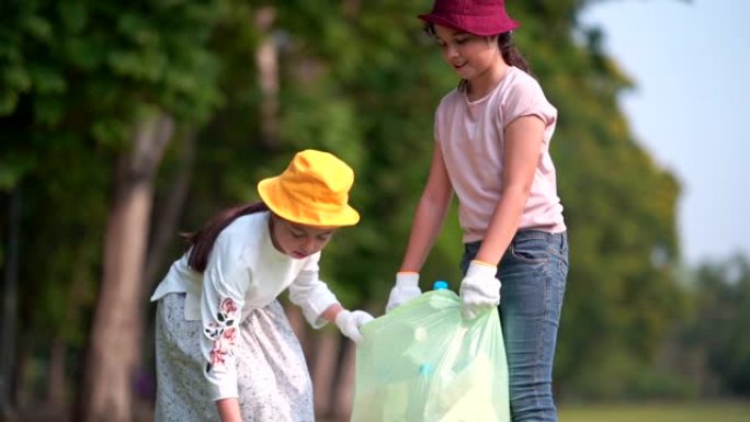 女孩和朋友帮助清理公园，捡起或垃圾收集地面上的垃圾