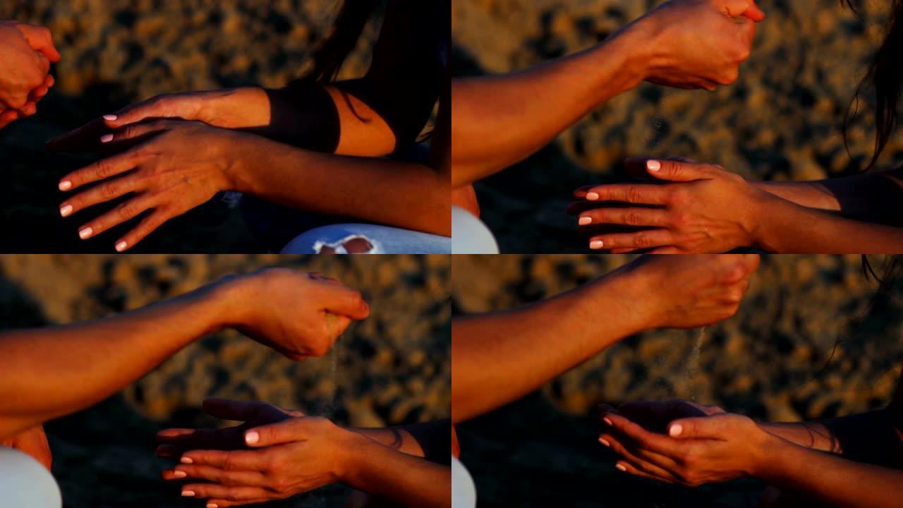 男友在夕阳下撒在女友手上的沙子
