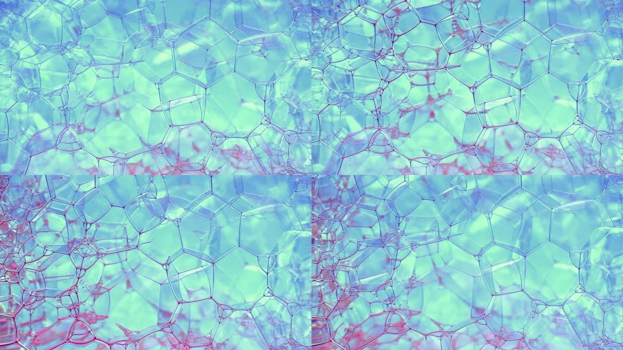 彩色肥皂泡沫与爆裂气泡背景。摘要生物结构，大分子模式。粉红色墨水填充了大量在液体中形成的蓝色小气泡。