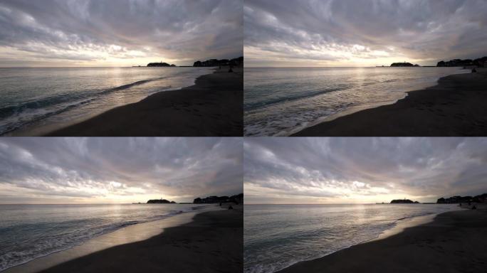 日本神奈川江之岛的日落。海浪对着海滩。