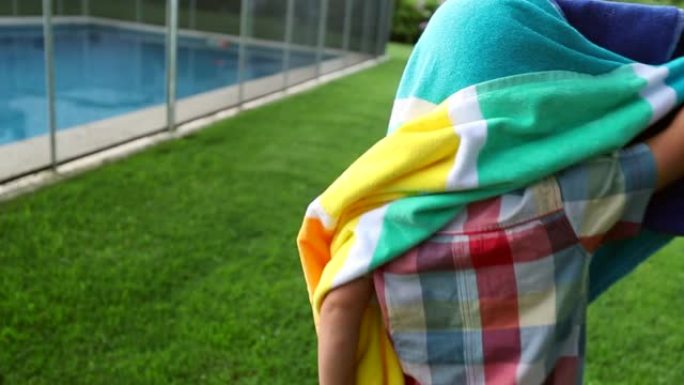 学步的男婴被游泳池毛巾覆盖