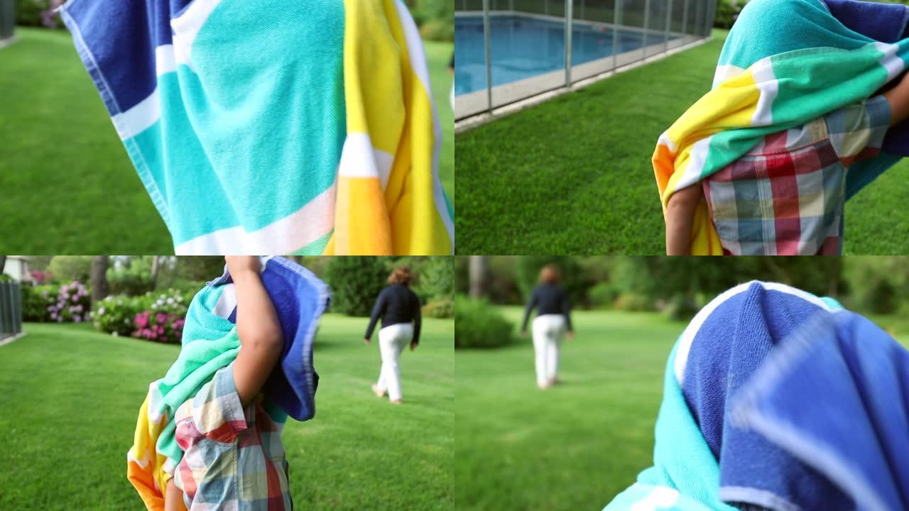 学步的男婴被游泳池毛巾覆盖
