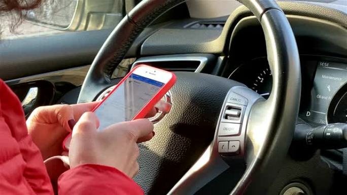 一名妇女在开车时使用智能手机。